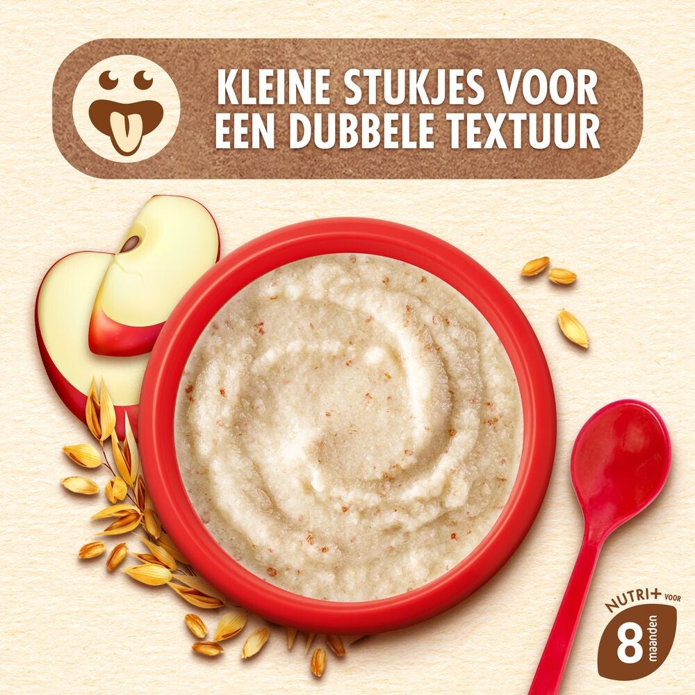 Rood kom havermout met appelstukjes en rode lepel, omgeven door graankorrels.