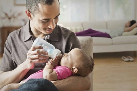 Vader die melk geeft aan zijn baby van Nestle baby&me