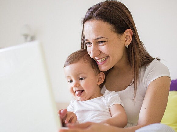 Mother and baby daughter playing together using laptop Mother and baby daughter playing together using laptop