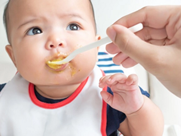 Un bébé mange une panade de fruit Nestlé Baby Fruit