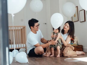 Des parents aident leur bébé à faire ses premiers pas