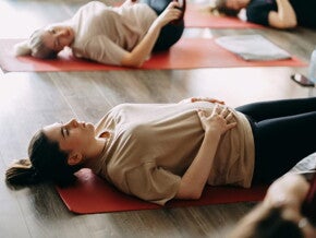 Personnes allongées sur des tapis de yoga en séance de relaxation