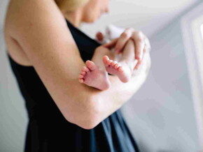 Une femme tient son bébé qui a des régurgitations – Nestlé Baby&Me
