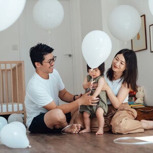 Des parents aident leur bébé à faire ses premiers pas