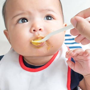 Un bébé mange une panade de fruit Nestlé Baby Fruit