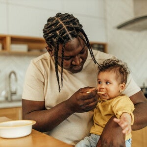 Un homme donne à manger à un bébé dans la cuisine
