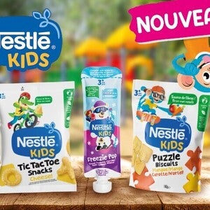 Des snacks Nestlé Kids dans des emballages colorés, posés sur une table en bois.