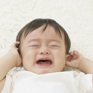 Un bébé pleure en se tenant les oreilles – Nestlé FamilyNes