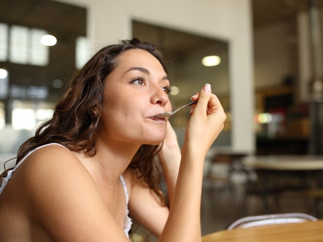 Vrouw eet met een lepel in een café