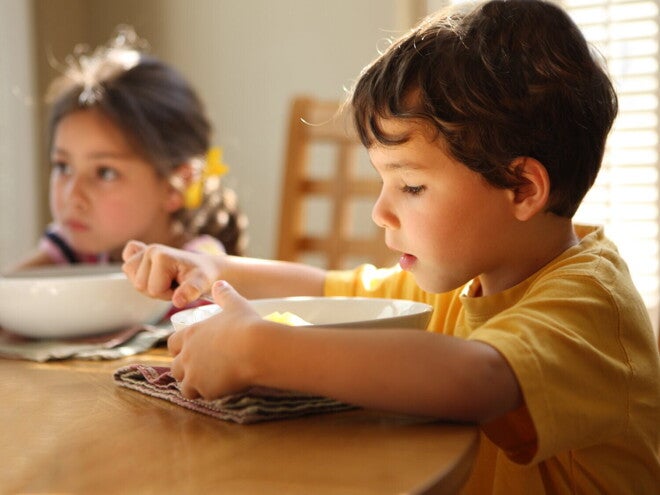 Deux enfants mangent à la table à manger