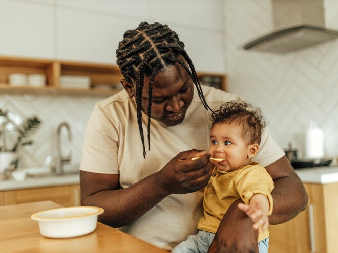 Un homme donne à manger à un bébé dans la cuisine