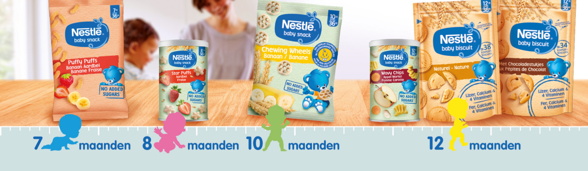 Nestlé babyvoeding verpakkingen voor verschillende leeftijden op een tafel.