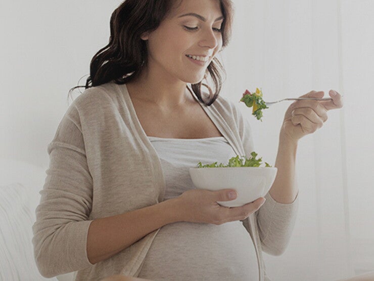 Pregnant woman eating salad