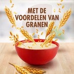 Rode kom met ontbijtgranen en tarwearen op houten oppervlakte.